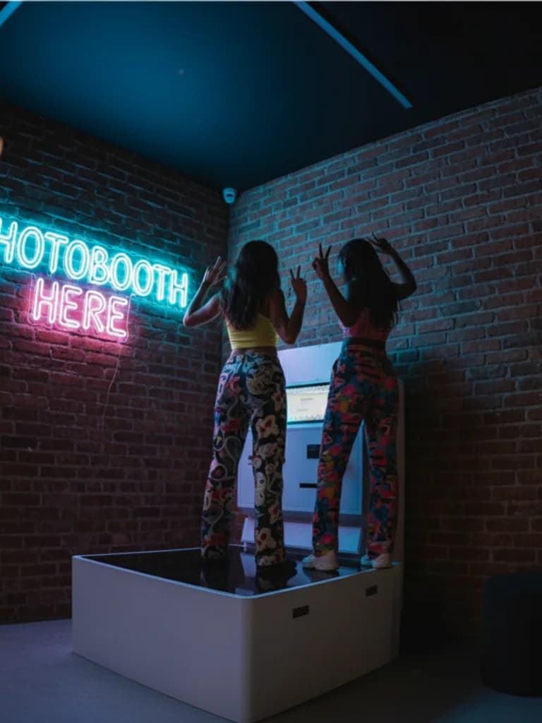 2 people using the Low Angle photo booth inside an arcade