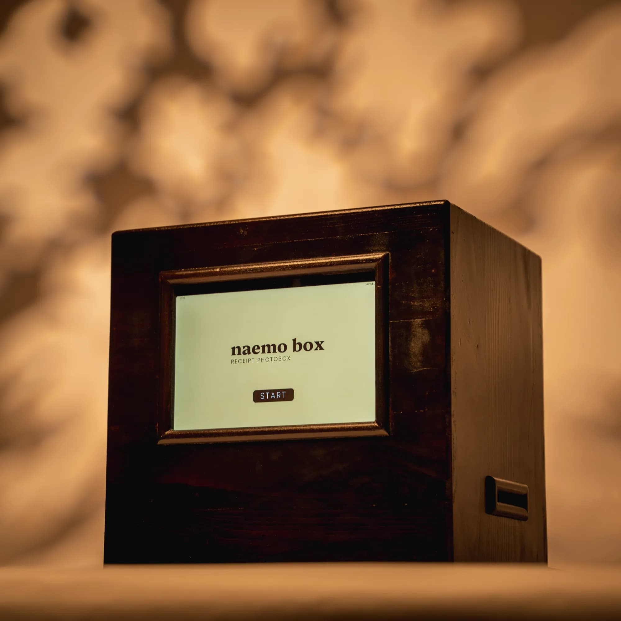 Naemo Box photo booth placed on a surface against a warm background