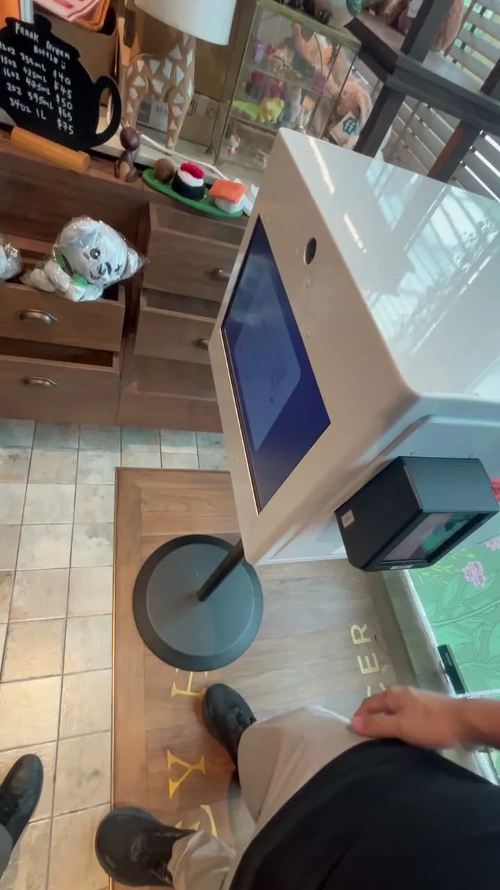 Customer using the Raon mini photo booth in a cafe