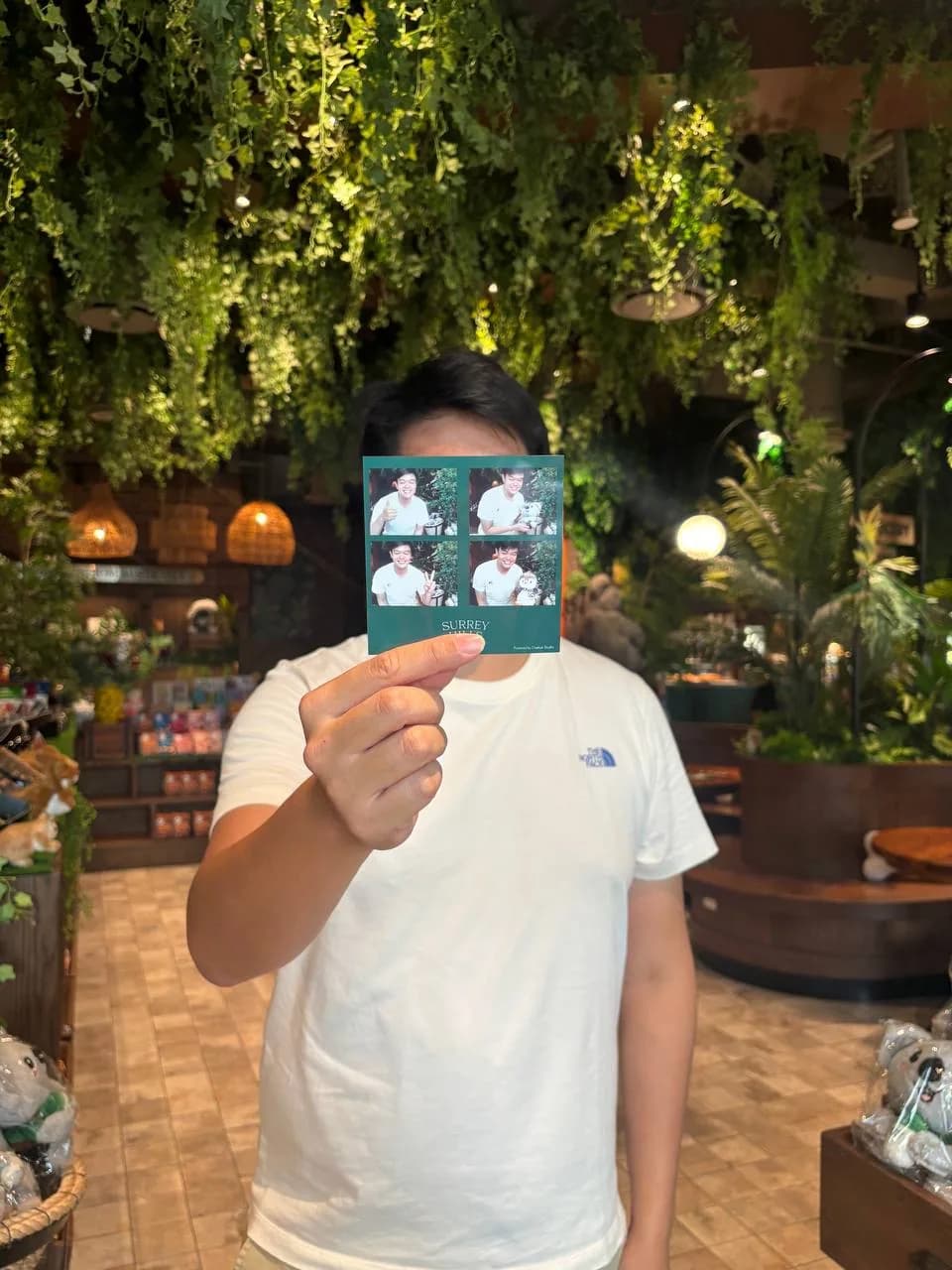 A person holding a 2 by 2 square photo strip in his hands