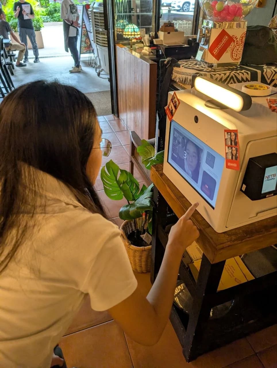A person interacting with the Raon mini photo booth machine