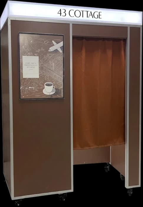 Café vintage photo booth in brown with a lit 43 Cottage sign and a poster board