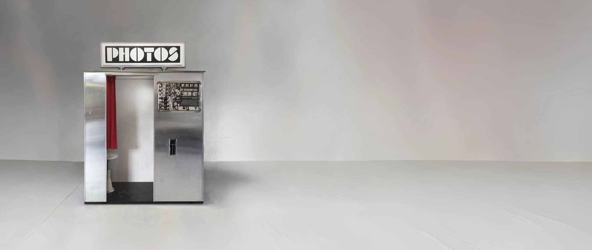 Vintage style photo booth with a PHOTOS light box in a studio