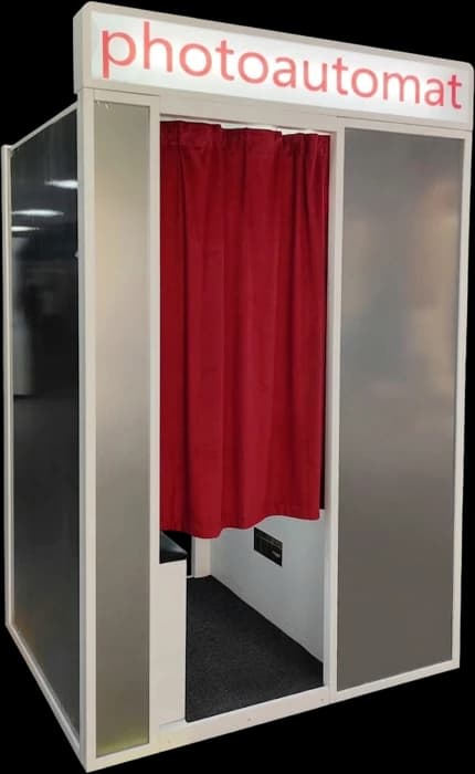 Automat vintage photo booth in silver with a photoautomat sign and red curtain