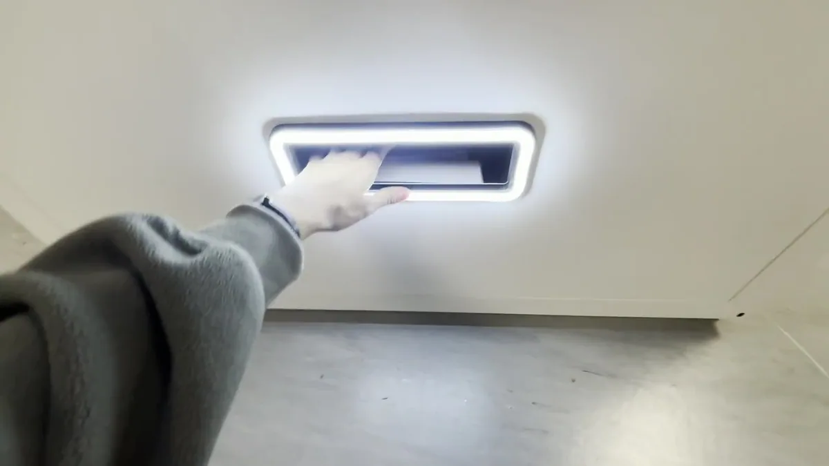 Collecting a test print from the lit print slot of a photo booth